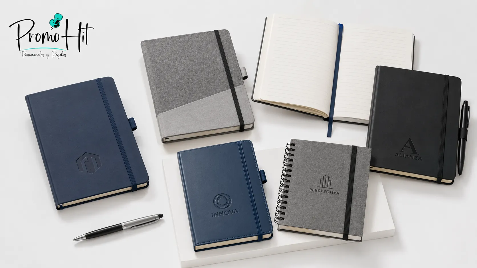 Agendas corporativas personalizadas en diferentes colores y tamaños con bolígrafos sobre fondo blanco.